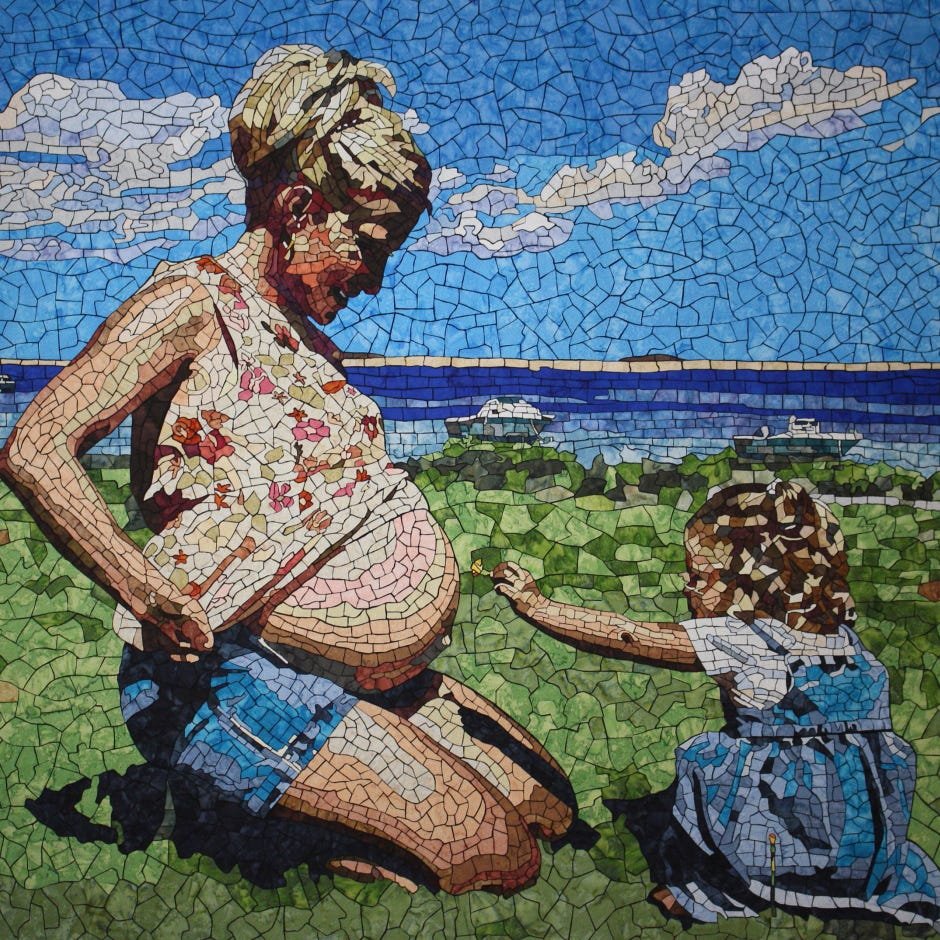 pregnant mother sitting on the grass with her daughter