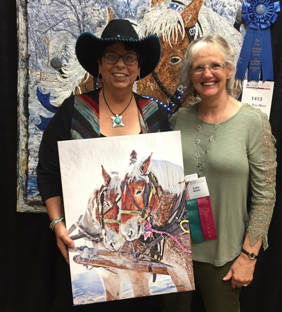 Kathy McNeil holding her painting